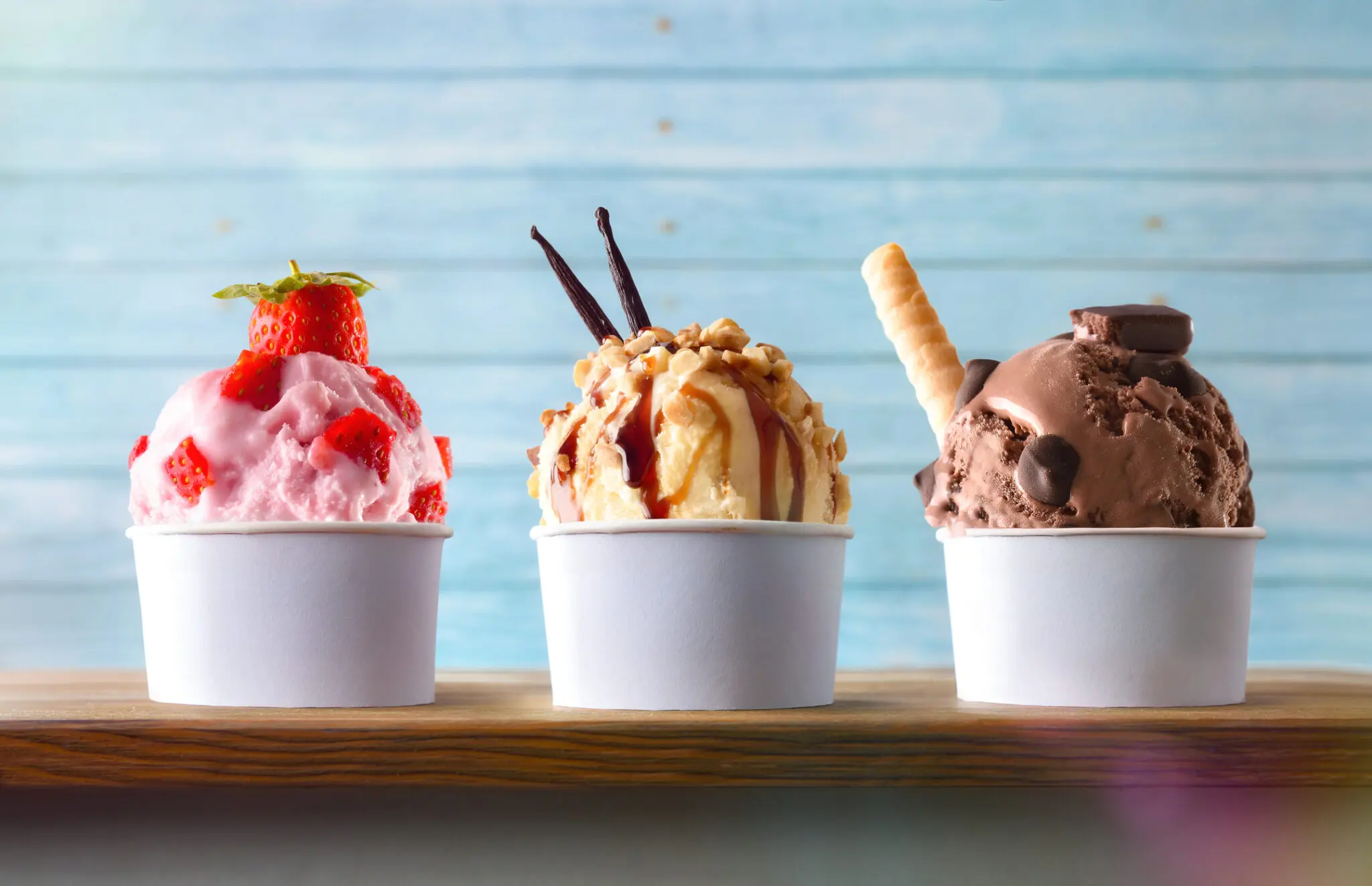 Three cups of assorted ice cream scoops.