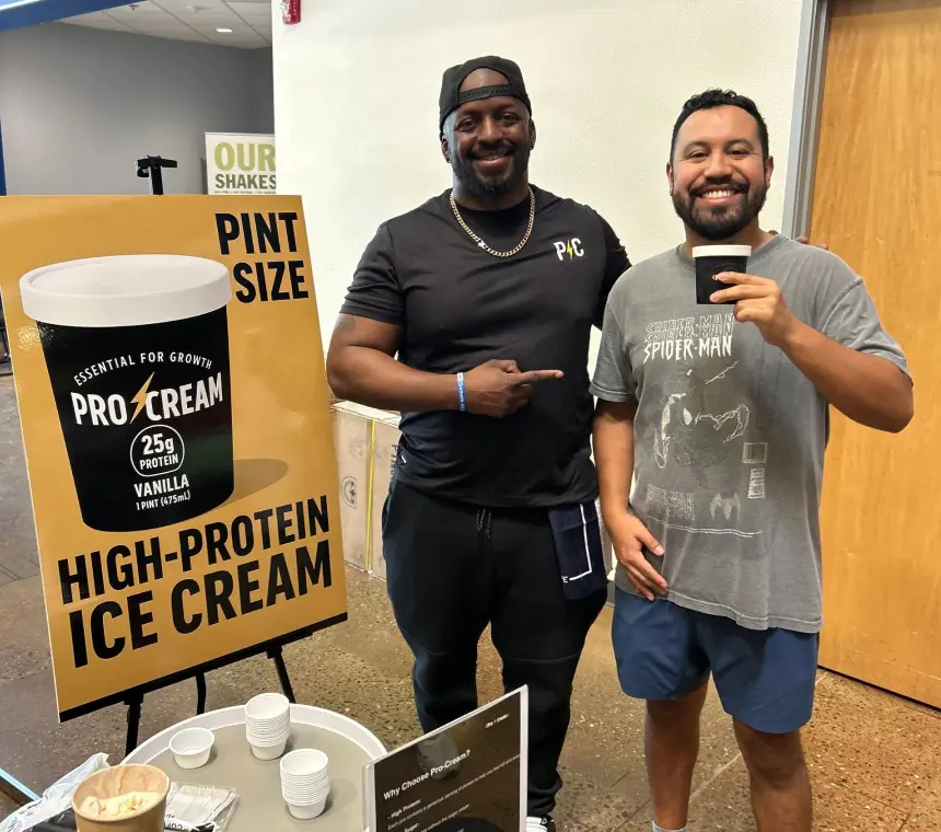 Two men enjoying high-protein ice cream at an event.